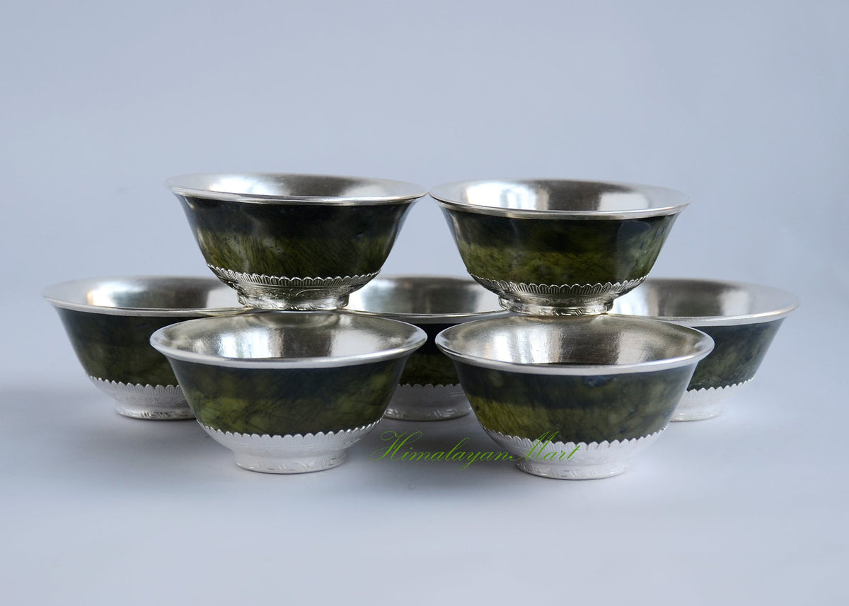Set of seven handcrafted brass water offering bowls on a Buddhist altar