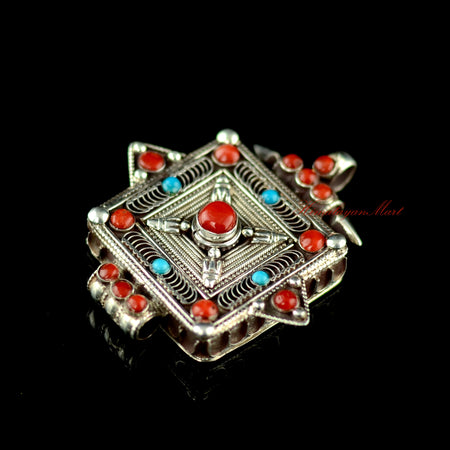 Right-side view of the Buddhist silver pendant with coral and turquoise gemstone accents.