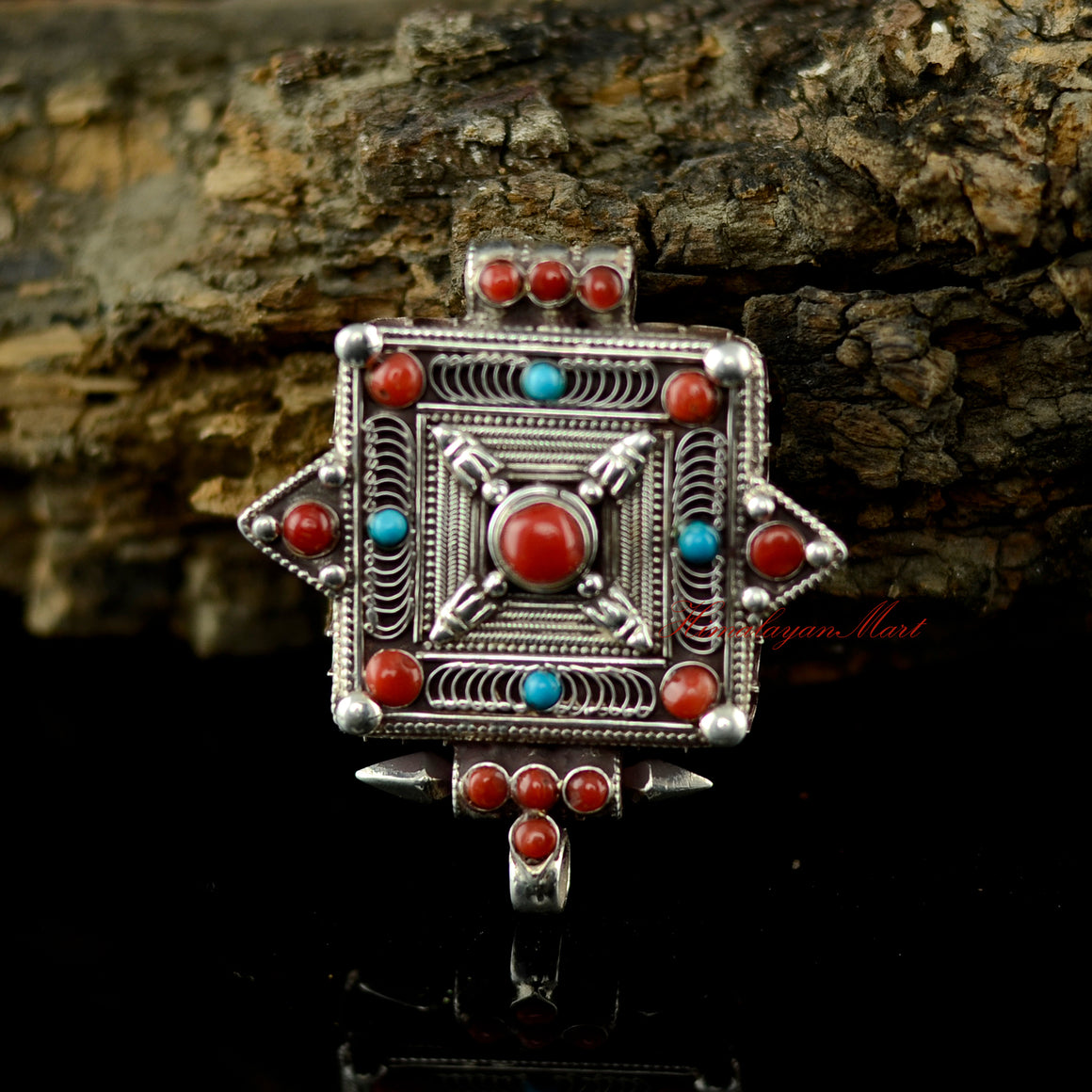 Handmade Buddhist silver pendant with coral and turquoise gemstone inlay, crafted in traditional Tibetan style.