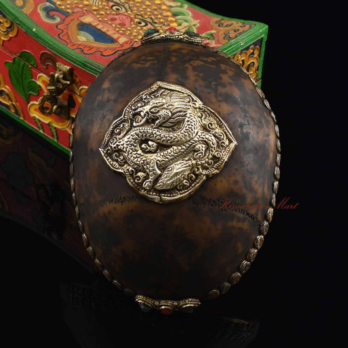 Dragon-embedded resin kapala, front view with metal skull border