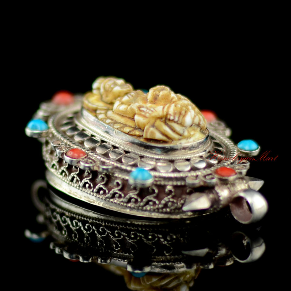 Left view of Dzambhala Wealth Deity Pendant highlighting intricate siko filigree carving in silver.