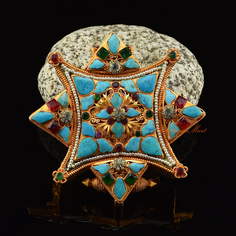 Front view of handmade Ghau Prayer Box Pendant in brass with gold, silver plating, and turquoise.