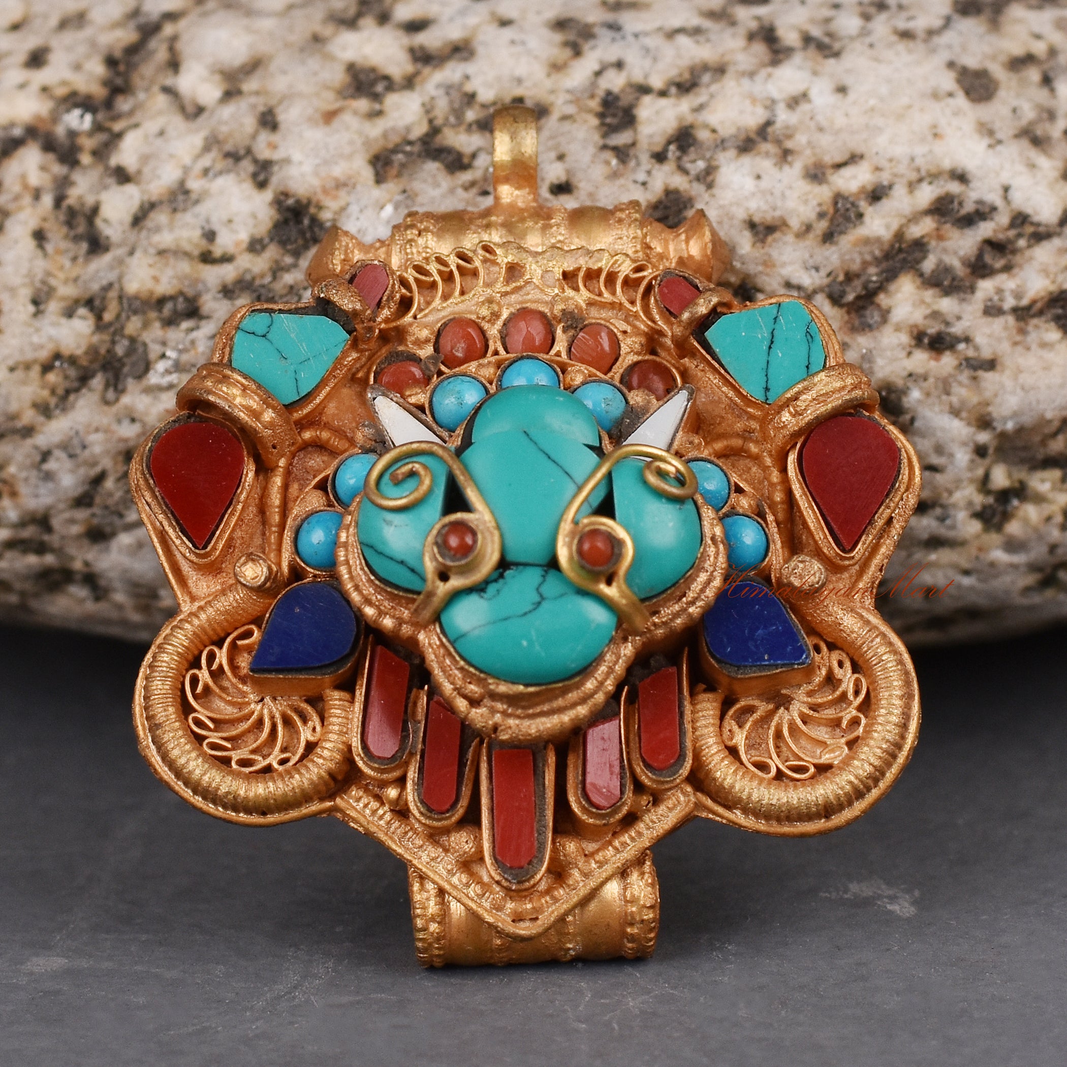 Bottom view of handcrafted Cheppu Face Ghau pendant highlighting intricate carvings and stone inlay.