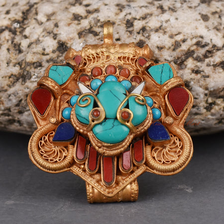 Bottom view of handcrafted Cheppu Face Ghau pendant highlighting intricate carvings and stone inlay.