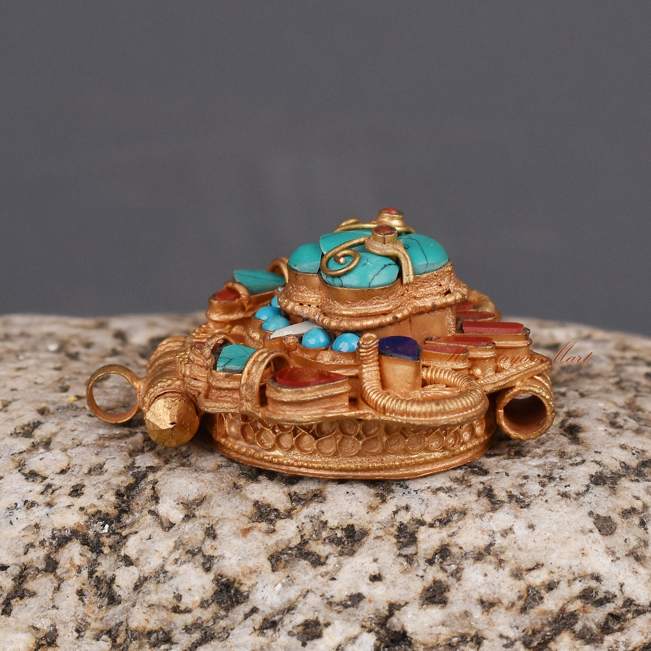 Left side view of Cheppu Face Ghau prayer box pendant with gold-plated finish and traditional stones.