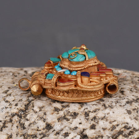 Left side view of Cheppu Face Ghau prayer box pendant with gold-plated finish and traditional stones.