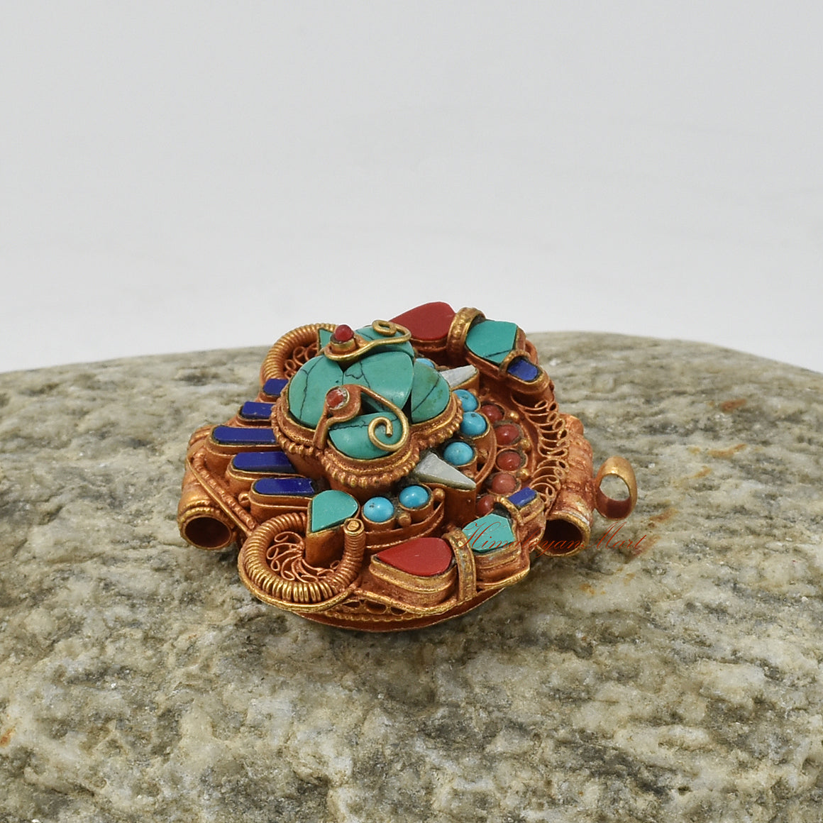 Alternative left-angle view of handcrafted Chhepu Face Ghau pendant, highlighting detailed carvings and gemstone inlay.