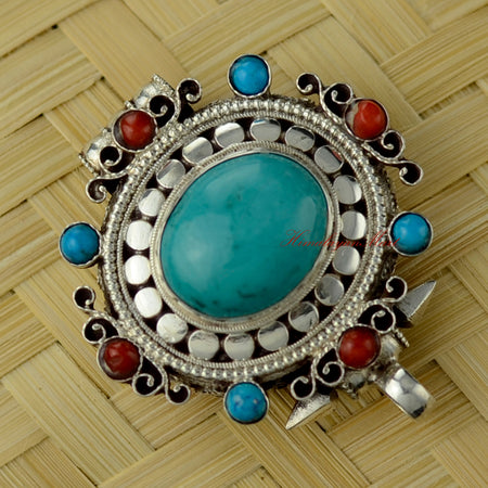 Angled right-down view of Himalayan Pendant Jewelry highlighting siko filigree and turquoise stone setting.