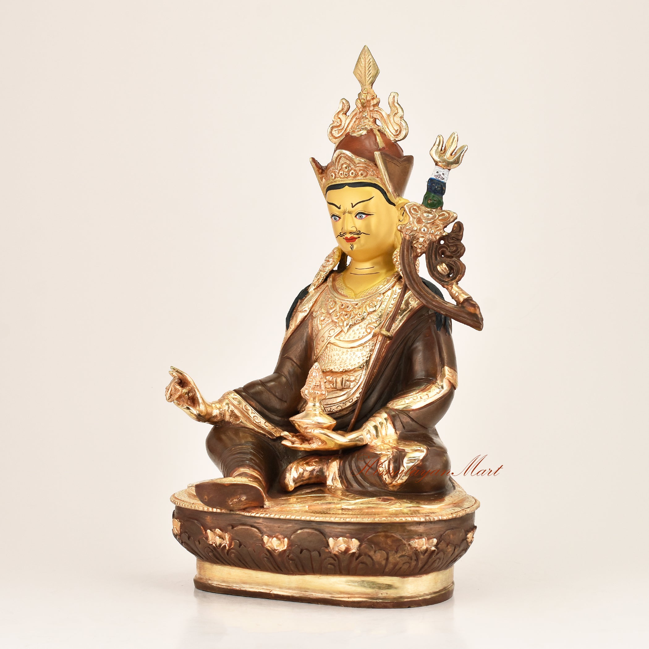 Left side view of the Lotus Born Master Statue revealing intricate copper alloy craftsmanship, khatvanga trident detailing, kapala skull cup, and flowing brocade robe engravings by Nepali master artisans