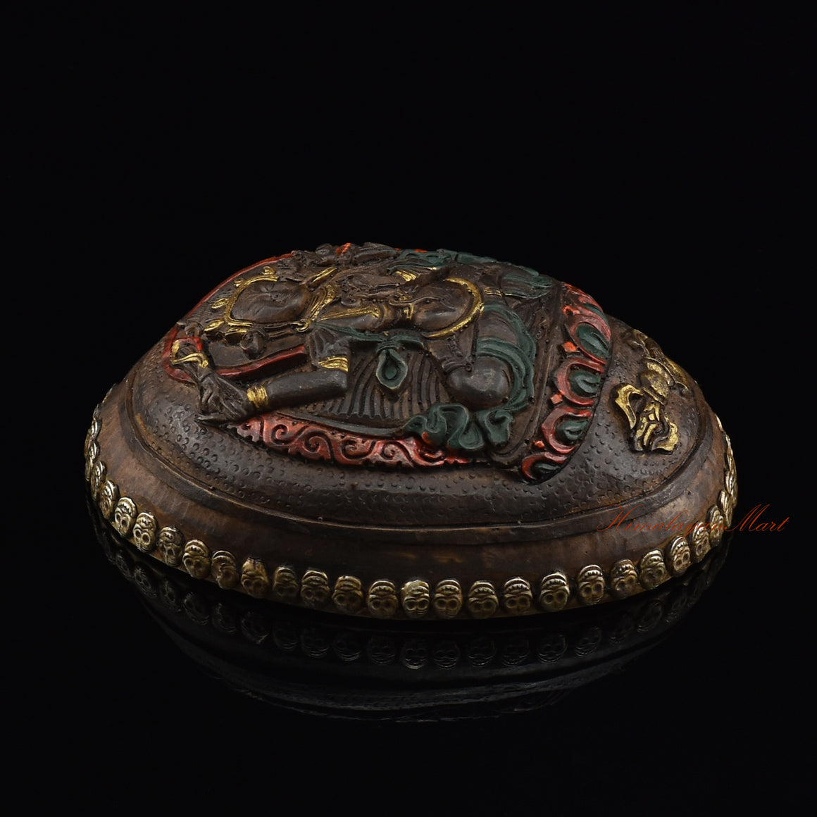 Left side view of the Manjushri Carved Resin Kapala highlighting the silver-plated copper accents