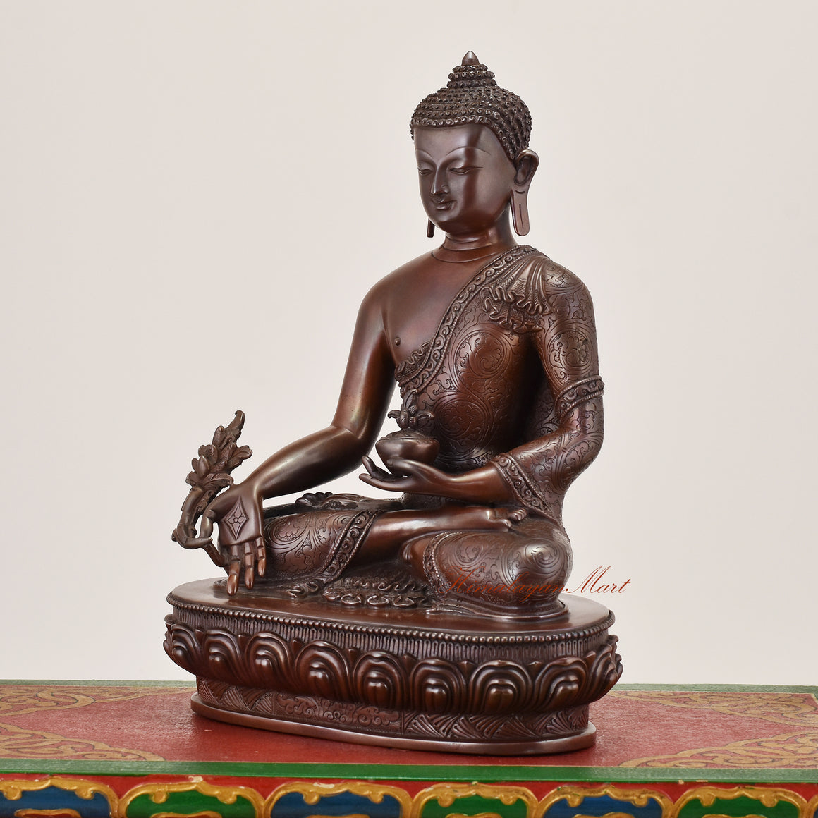 Left-side view of Medicine Buddha Idol sacred copper alloy statue highlighting detailed robes and symbolic healing posture