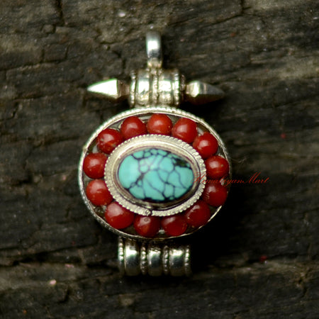 Nepalese Handcrafted Pendant in solid silver with a large turquoise center stone and coral accents.