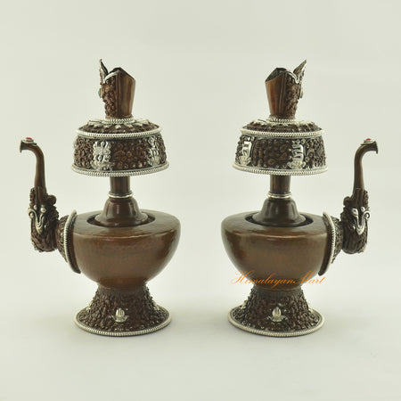 Angled view of the Oxidized Copper Bhumba Set showing left and right sides, highlighting hand-carved Buddhist symbols.