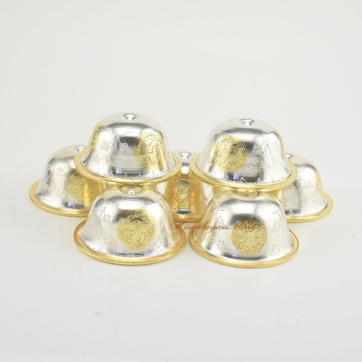Top-down view of Seven Tibetan Offering Bowls showing detailed hand-carved Buddhist motifs.