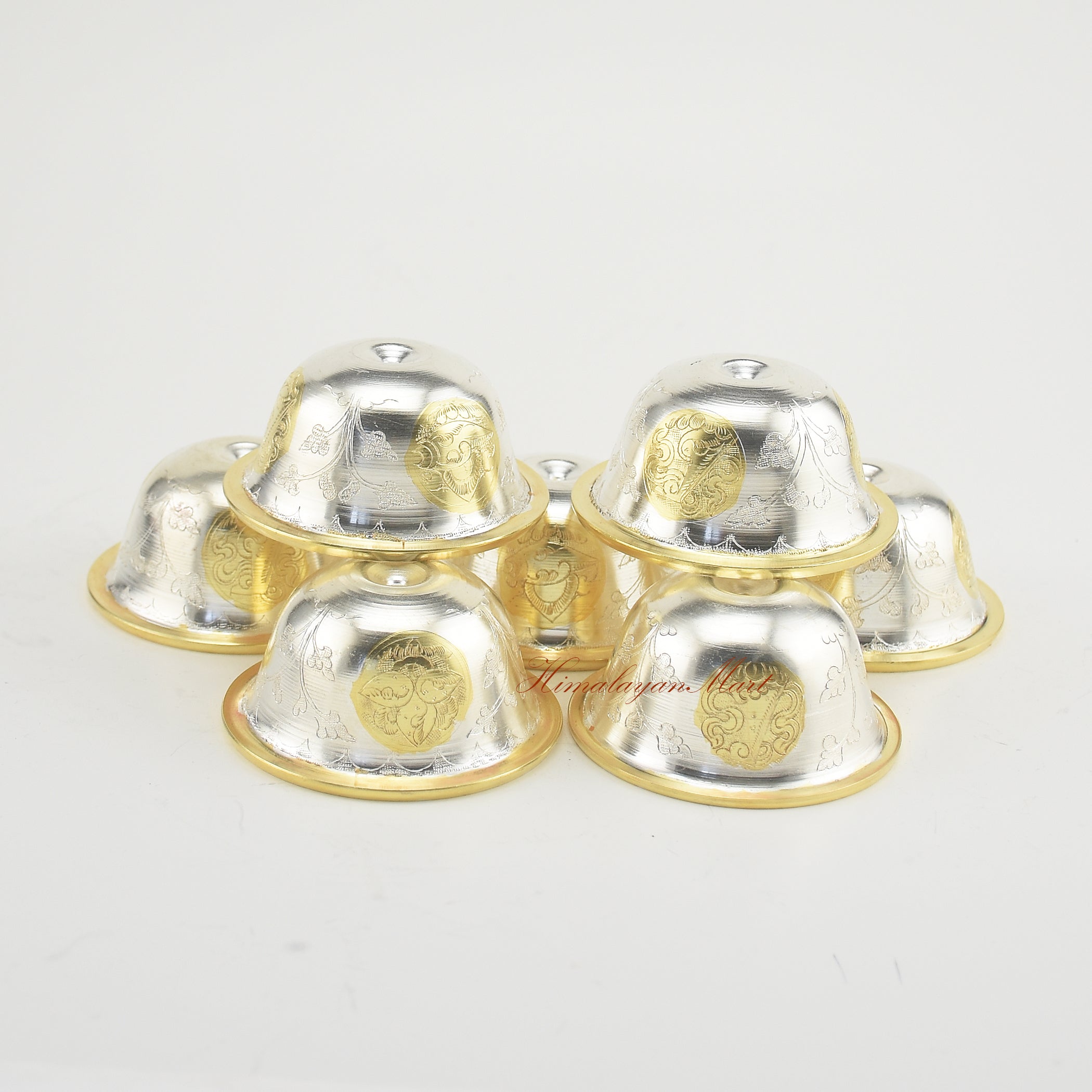 Top-down view of Seven Tibetan Offering Bowls showing detailed hand-carved Buddhist motifs.