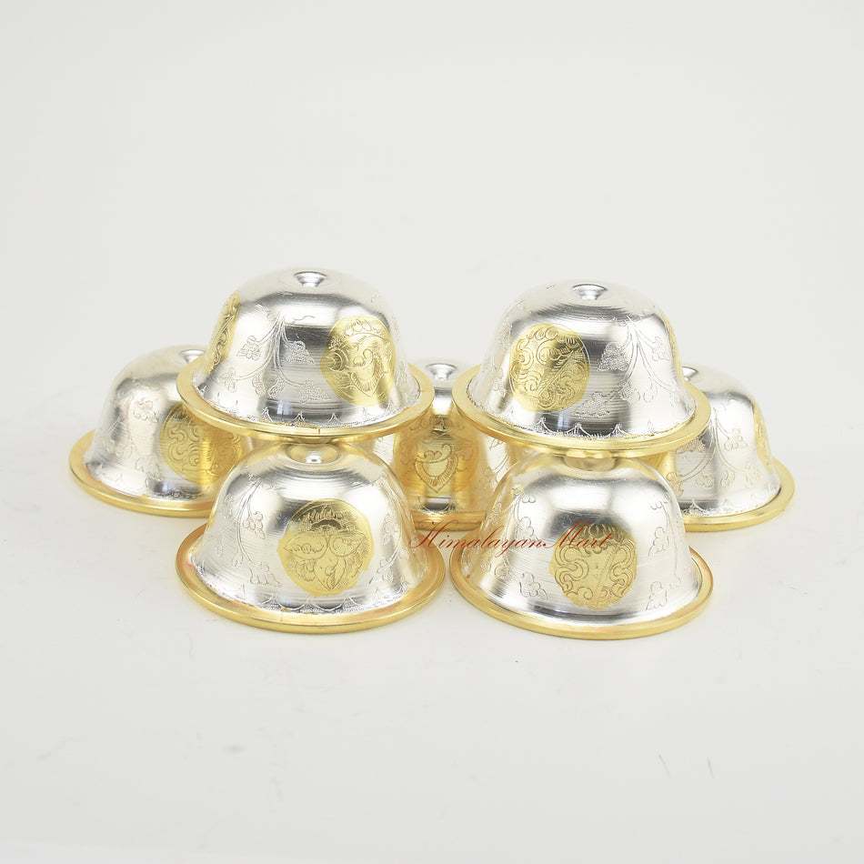 Top-down view of Seven Tibetan Offering Bowls showing detailed hand-carved Buddhist motifs.