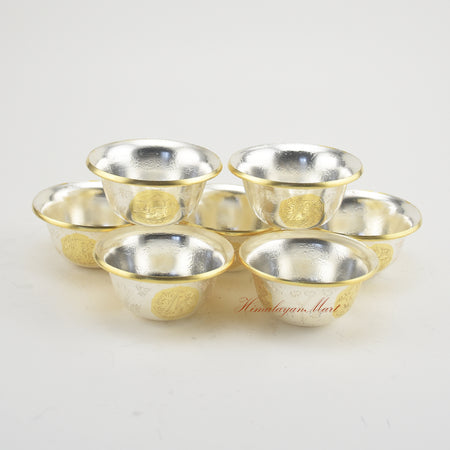 Complete set of Seven Tibetan Offering Bowls displayed on a Buddhist shrine for ritual practice.