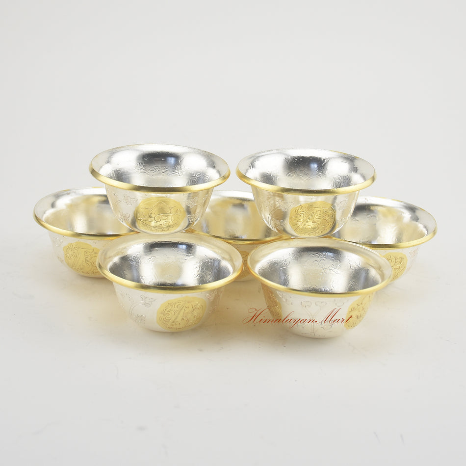 Complete set of Seven Tibetan Offering Bowls displayed on a Buddhist shrine for ritual practice.