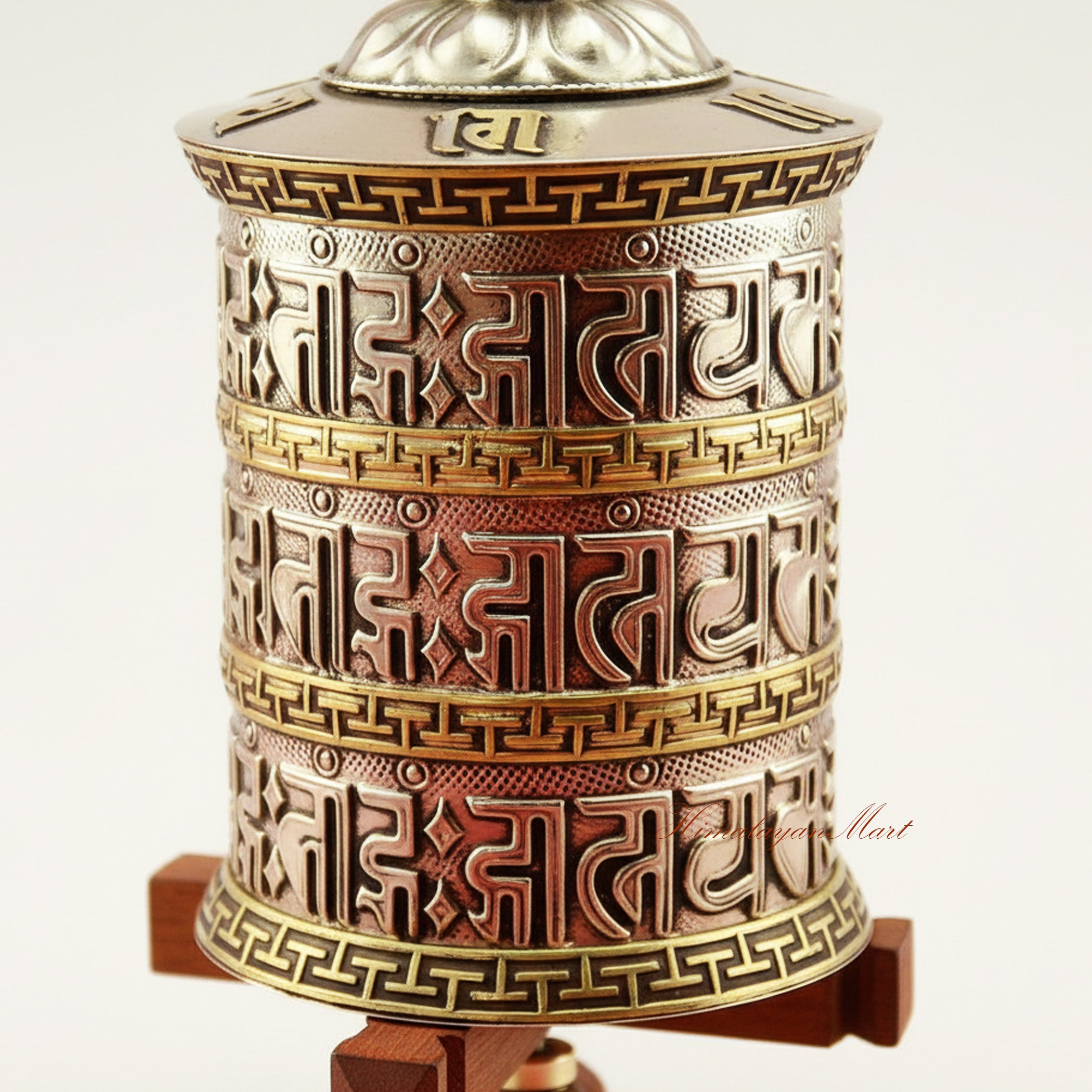 Close-up of Tabletop Mani Prayer Wheel showing detailed mantra carvings and decorative patterns on copper and brass cylinder.