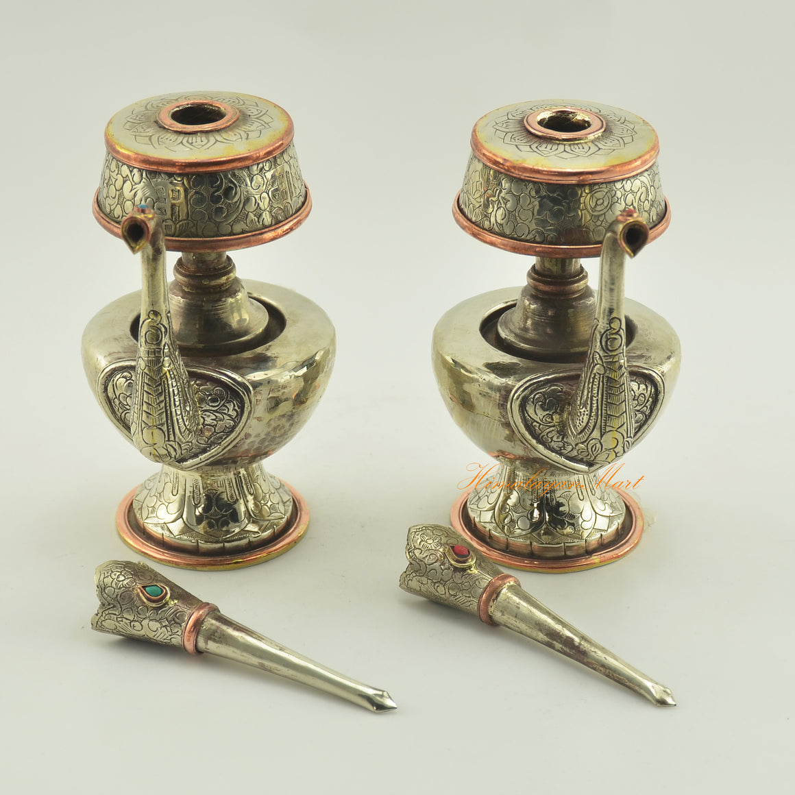 Close-up of Tibetan Buddhist Ritual Bhumba set parts displaying white metal alloy, copper rings, and gemstone inlay