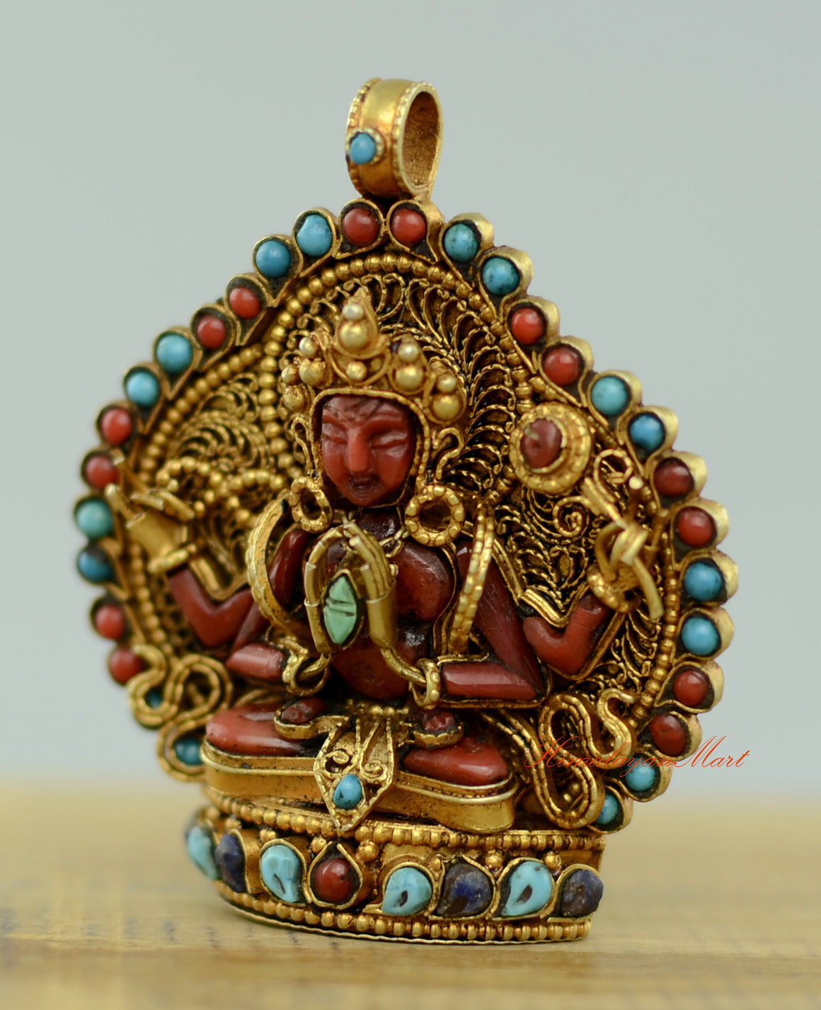 Left-side view of the Tibetan Chenrezig Locket emphasizing detailed hand-carved filigree and gemstone inlay.