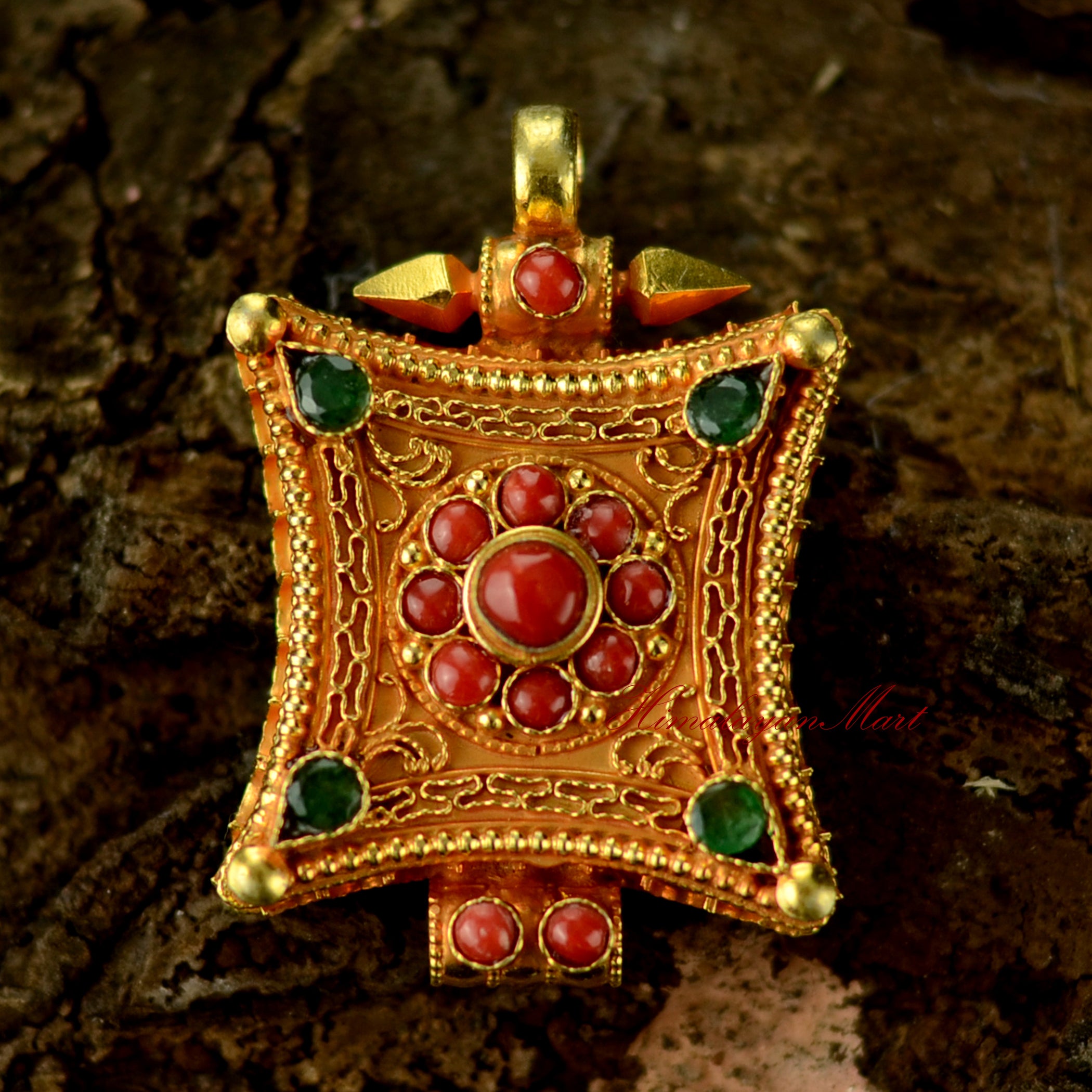Handcrafted Tibetan gemstone pendant in silver with intricate filigree and coral and emerald gemstones.