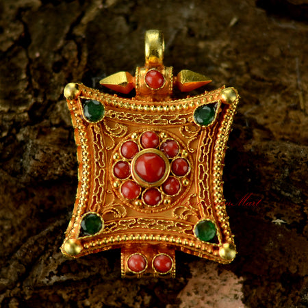 Handcrafted Tibetan gemstone pendant in silver with intricate filigree and coral and emerald gemstones.