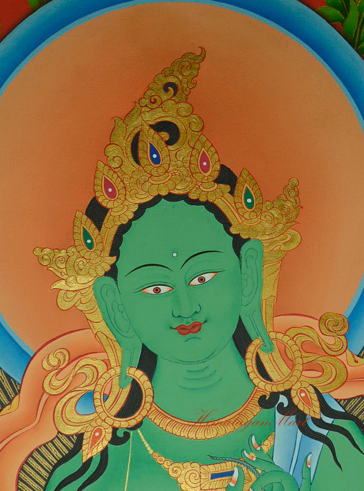 Detailed view of Green Tara’s serene face from the Tibetan Thangka, painted with gold accents.