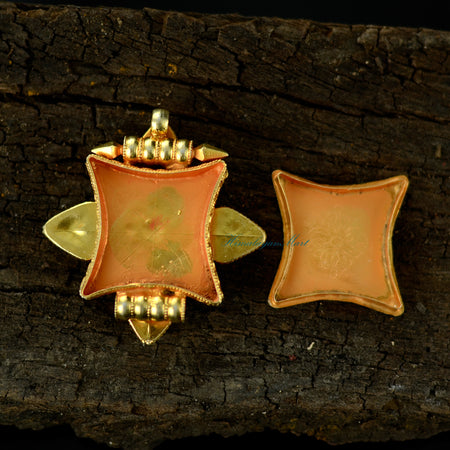 Opened Tibetan pendant jewelry showing interior detailing with silver craftsmanship and gemstone accents.