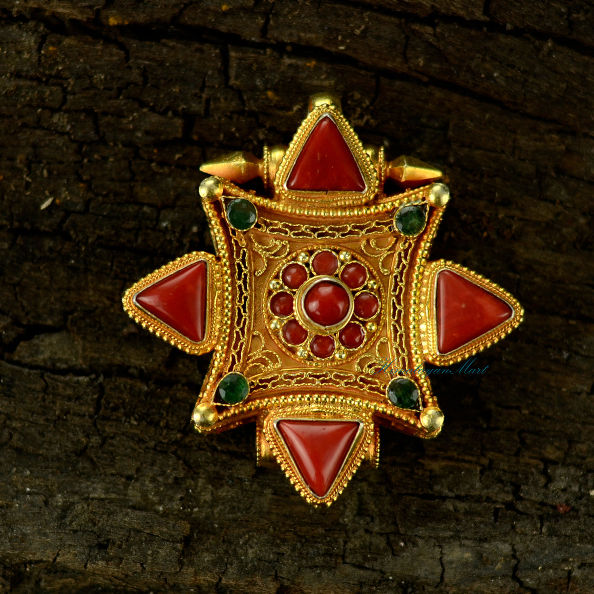 Handcrafted Tibetan pendant jewelry made of silver with detailed filigree and large coral and emerald gemstones.