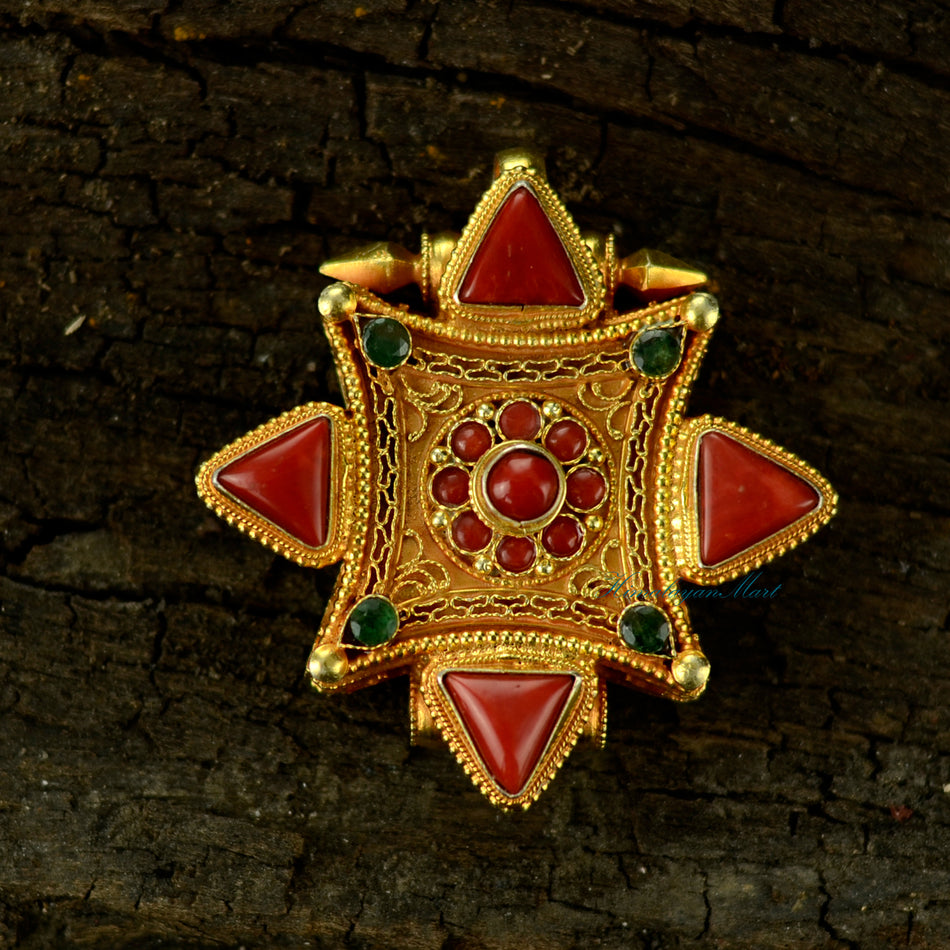 Handcrafted Tibetan pendant jewelry made of silver with detailed filigree and large coral and emerald gemstones.