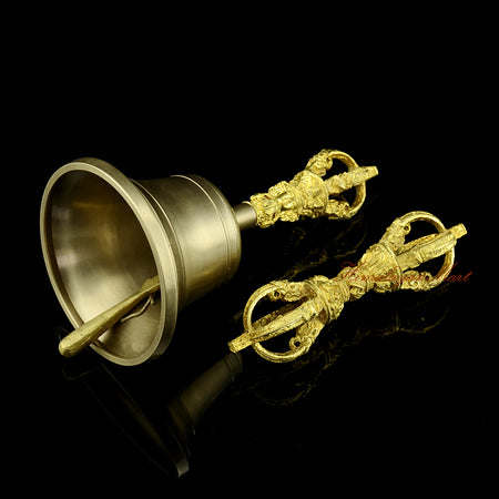 Left side view of copper and bronze ritual bell and Vajra, showing the antique-style patina and yellow handle detail