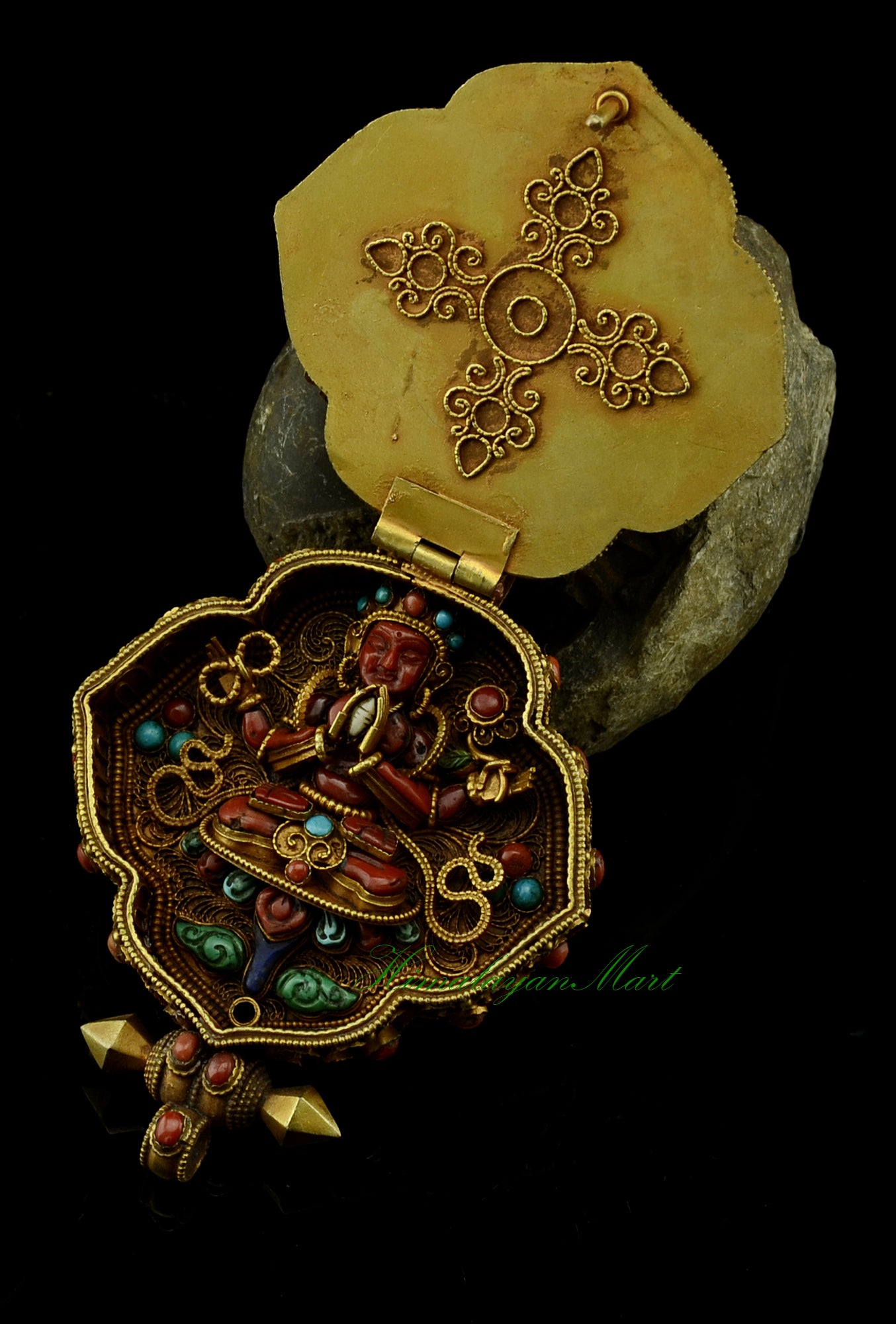 Opened Tibetan Ghau Pendant showing coral-carved Four-Armed Chenrezig inside.